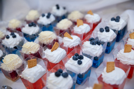 Delicious and Colorful Desserts Presented in Festive Cups Garnished with Berries and Creamの写真素材