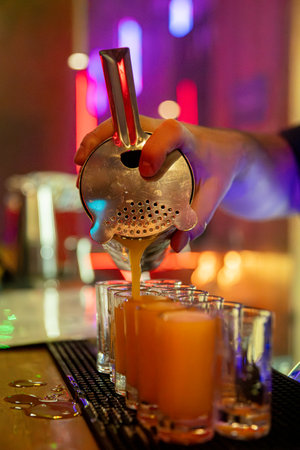 Craft Cocktail Preparation in a Contemporary Bar Setting That Engages Customers and Guests