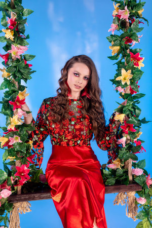 A Vibrant Portrait of a Young Woman Captured Gracefully on a Beautiful Floral Swing