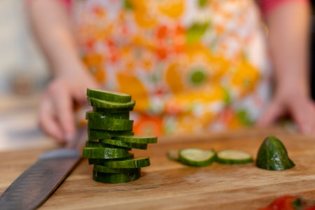 Freshly Sliced Cucumbers Placed Gracefully on a Rustic Wooden Cutting Board Surfaceの写真素材