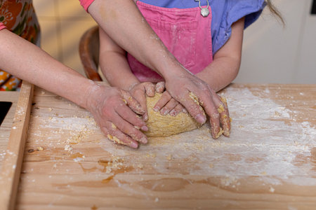 Hands methodically knead dough in a warm, cozy kitchen thats filled with love, joy, and creativity