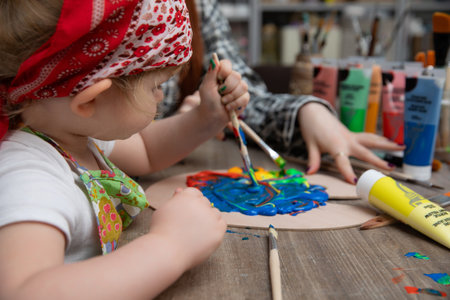Engaging child painting process in art studio using various techniques and materialsの写真素材