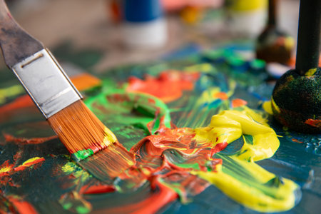 The vibrant paint blends beautifully on the artists palette alongside a brush, creating artの写真素材