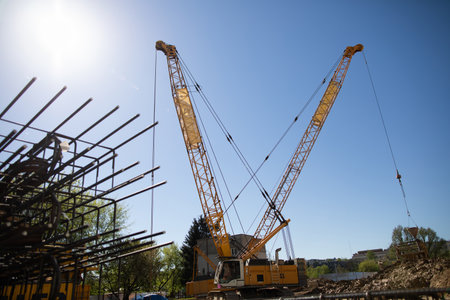A Construction Site Featuring Cranes and Steel Beams Under a Bright and Clear Sky