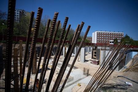 A construction site featuring rebar prominently placed at the buildings foundation level
