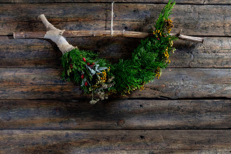 This is a Stunningly Beautiful Natural Wreath Adorned with Lush Greenery on a Rustic Wood Backgroundの写真素材