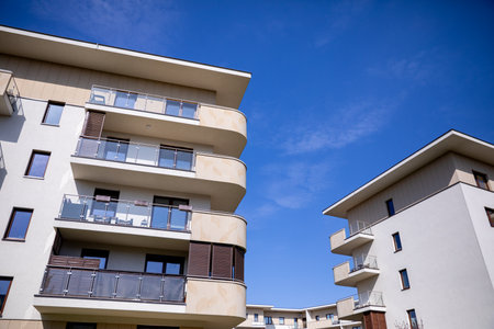 A collection of modern residential buildings set against a clear blue sky, showcasing innovationの写真素材