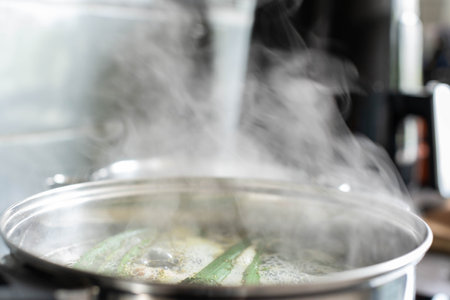 A pot of fresh vegetables cooks on the stove, filling the kitchen with comforting aromasの写真素材
