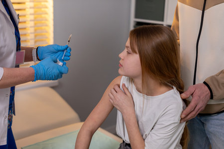 A Young Girl Receiving Vaccination in a Medical Setting That Ensures Her Wellbeing and Safetyの写真素材