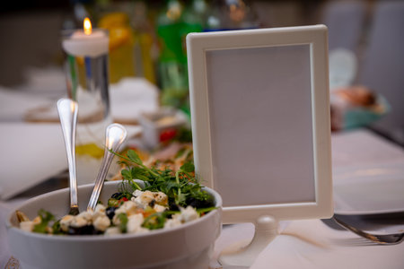 An Elegant Dining Setup that includes a beautiful Salad Presentation and Charming Candlesの写真素材
