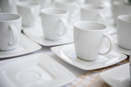 An Elegant Set of White Cups Perfectly Arranged on Plates for Exquisite Dining Experiencesの写真素材