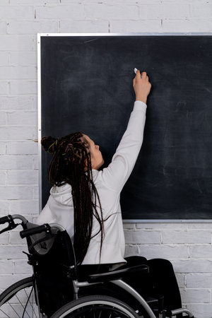 An Empowered Individual in a Wheelchair Passionately Writing and Expressing Ideas on a Chalkboard
