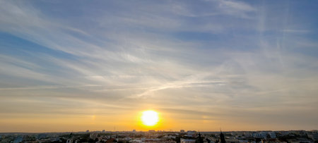A Stunningly Beautiful Sunrise Over the Vibrant Cityscape with Wispy Clouds in the Sky