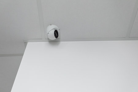 Surveillance Camera Strategically Mounted on Ceiling in a Clean, Minimalist Setting and Design