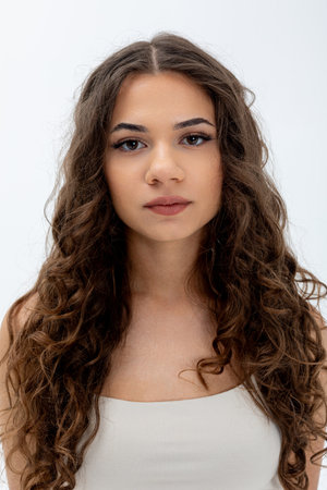 A stunningly beautiful curly haired model exuding confidence and charm in her expression