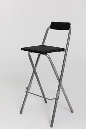 This is a modern folding bar stool designed with a comfortable black cushioned seat