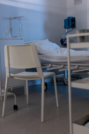 A Quiet Hospital Room with a Bed and a Chair for Patients in Need of Care and Comfortの写真素材