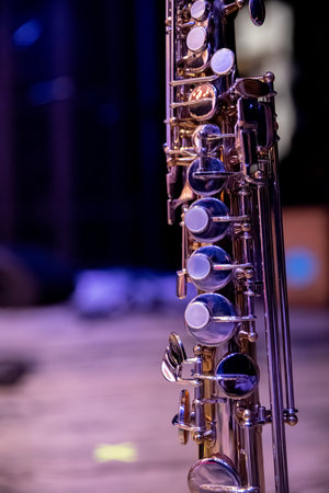 A CloseUp of a Sleek and Shiny Silver Saxophone Set Against a Softly Dim Background
