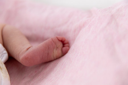 An Adorable and Cute Baby Foot Resting Comfortably on a Soft and Gentle Pink Fabric Background