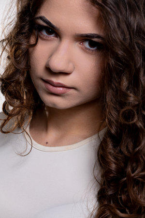 This is a captivating portrait featuring a Young Woman who has beautiful Curly Hairの写真素材