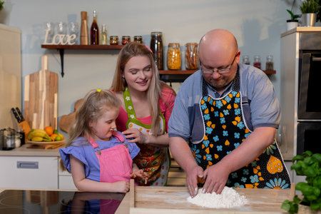 A family joyfully cooking together in a bright and vibrant kitchen filled with happinessの写真素材