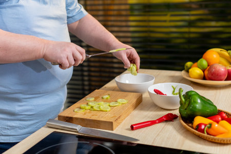 A Person Engaged in Preparing Fresh and Colorful Vegetables Within a Modern Kitchen Settingの写真素材