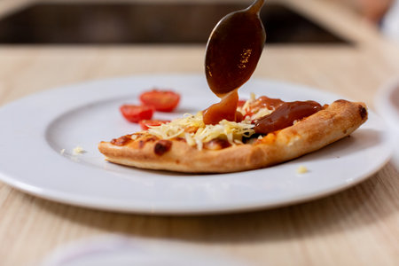 A Truly Delicious and Flavorful Pizza Served with Exquisite Sauce and Fresh Ingredients on a Plateの写真素材