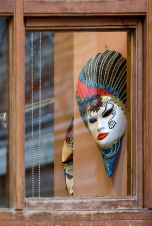 Venetian masks across old windowの写真素材