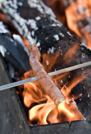 Sausage cooking on the campfireの写真素材