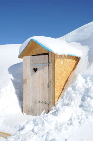 Wooden toilet box in the middle of snow on the alpsの写真素材