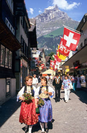 Engelberg, Switzerland - 2 May 2007: two young girls dressed in traditional costumes walk in the main street of Engelberg in the Swiss Alpsのeditorial素材