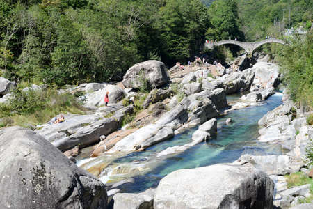 Lavertezzo, Switzerland: 1 September 2014: Tourists visiting the famous roman bridge of Lavertezzo on Verzasca valley on the italian part of Switzerlandのeditorial素材