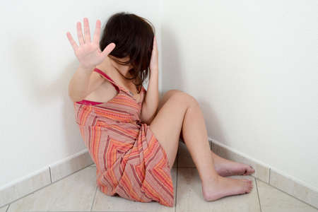 Domestic violence against a woman in a corner