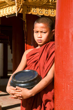Bagan, Myanmar - 8 February 2010: Young monk with a rice container at Shwezigon pagoda at the archaeological site of Bagan on Myanmarのeditorial素材