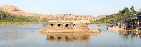 Hampi, India - 11 January 2015: People washing clothes and crossing the river by boat at Hampi on Indiaのeditorial素材
