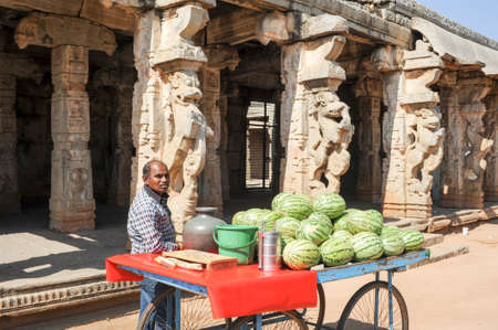 Hampi, India - 12 January 2015: Man selling watermelon in front of the Royal Centre on Hampi, Indiaのeditorial素材