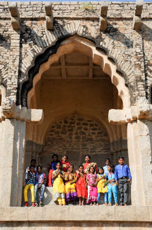 Hampi, India - 12 January 2015: school class with teacher posing under the arch of Elephant Stables at Royal Centre on Hampi, Indiaのeditorial素材