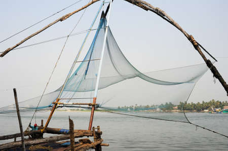 FORT KOCHI, INDIA - 16 JANUARY 2015: fishermen operate a Chinese fishing net based on ancient technology and traditional materials, ropes and stones at Fort Kochi, Kerala, Indiaのeditorial素材