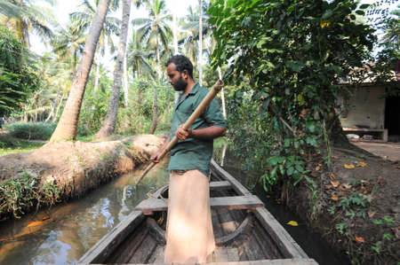 Kollam, India - 19 January 2015: a men rowing his canoe on a river of the backwaters at Kollam on Indiaのeditorial素材