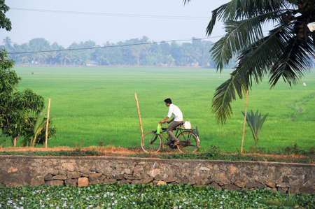 Kollam, India - 20 January 2015: Man traveling with his bike near Alleppey on Kerala backwaters, Indiaのeditorial素材