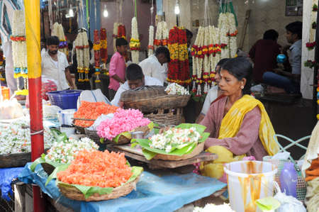 Mysore, India - 24 January 2015:  Indian vendor selling flowers to the customers in the Devaraja market at Mysore on Indiaのeditorial素材