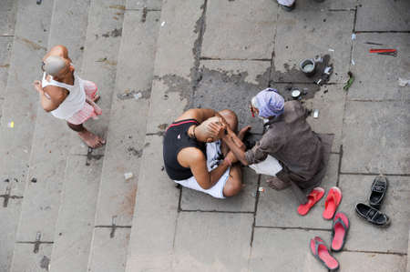 Varanasi, India - 28 January 2015: Man cutting hair on the Ghats of river Ganges in holy city of Varanasi on Indiaのeditorial素材