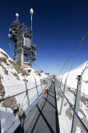 Engelberg, Switzerland - 18 February 2015: People walking on the Cliff Walk in front of transmission antennas of mount Titlis on the Swiss alpsのeditorial素材
