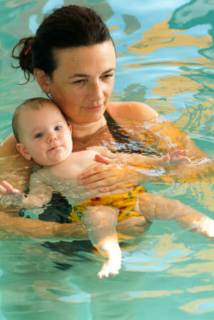 Lugano, Switzerland - 18 October 2007: Adorable baby enjoying swimming in a pool with his mother, early development class for infants teaching children to swim and diveのeditorial素材