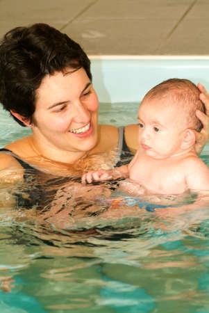 Lugano, Switzerland - 18 October 2007: Adorable baby enjoying swimming in a pool with his mother, early development class for infants teaching children to swim and diveのeditorial素材