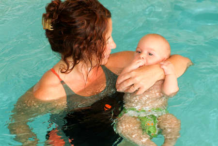 Lugano, Switzerland - 18 October 2007: Adorable baby enjoying swimming in a pool with his mother, early development class for infants teaching children to swim and diveのeditorial素材