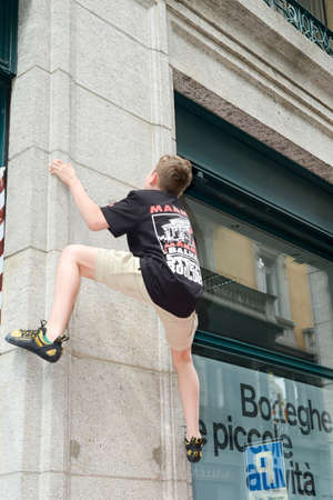 Lugano, Switzerland - 9 May 2015: Man climbing a house wall on street boulder contest at Lugano on Switzerlandのeditorial素材