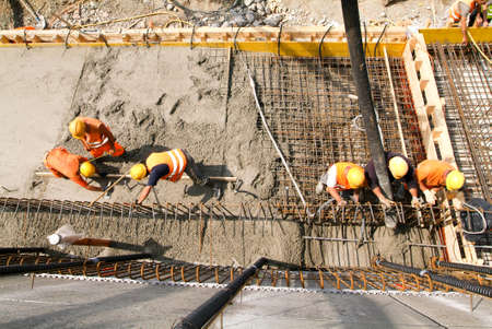 Bissone Switzerland  22 May 2009: Street workers pouring cement with a pump into a highway construction at Bissone on Switzerlandのeditorial素材