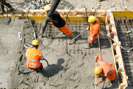 Bissone Switzerland  22 May 2009: Street workers pouring cement with a pump into a highway construction at Bissone on Switzerlandのeditorial素材