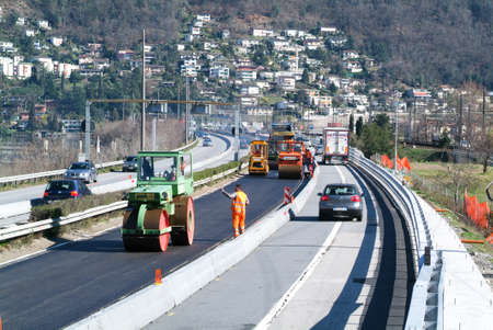 Bissone Switzerland  8 March 2007: Workers and vehicles during the asphalting of the highway at...